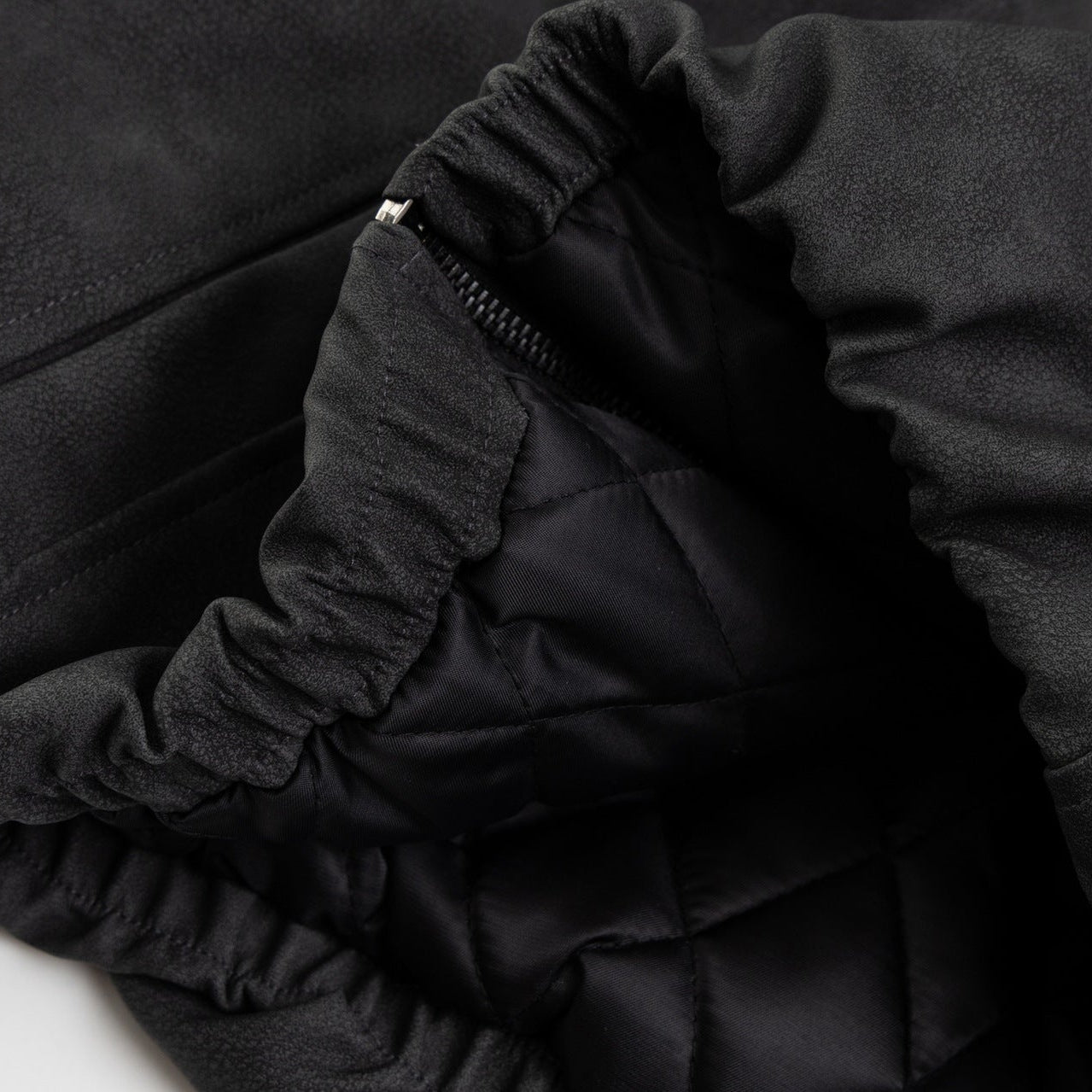 Close up detail of ARC NightDye black washed jacket hem texture and stitching vintage streetwear fabric