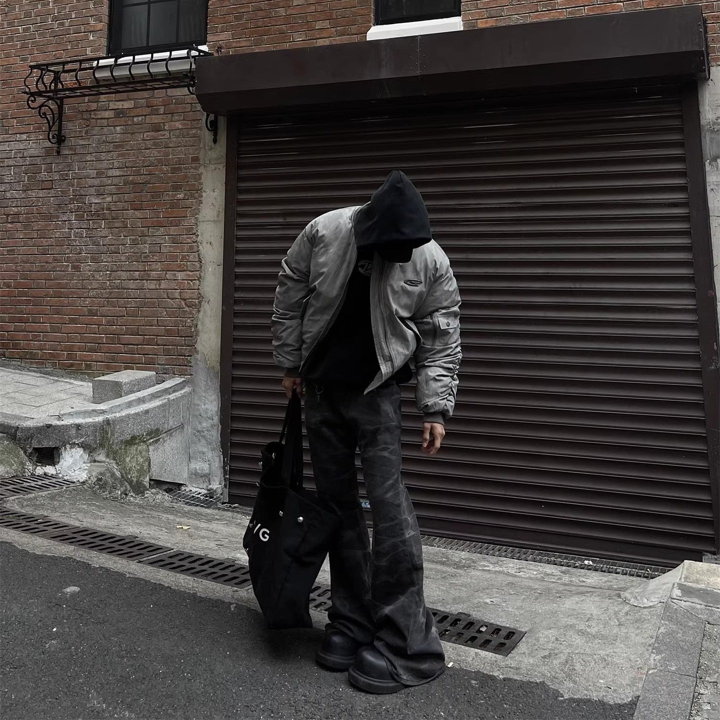 Model wearing RuinForm gray retro streetwear flight jacket in urban street setting