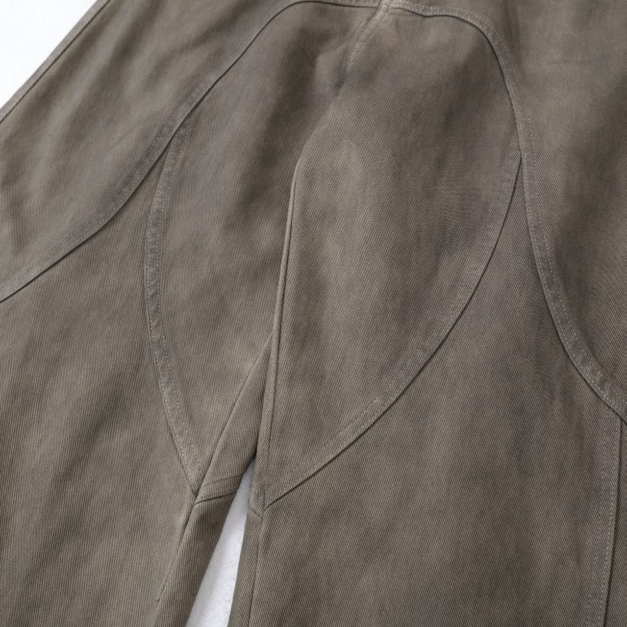 Close up detail of ARC DriftForm brown vintage washed denim pants stitching and panel construction