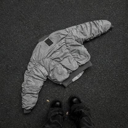 RuinForm gray retro flight jacket laid on asphalt showing ruched sleeve construction
